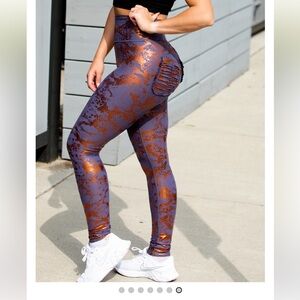 Minibeast Metallic in Orange and Black leggings.